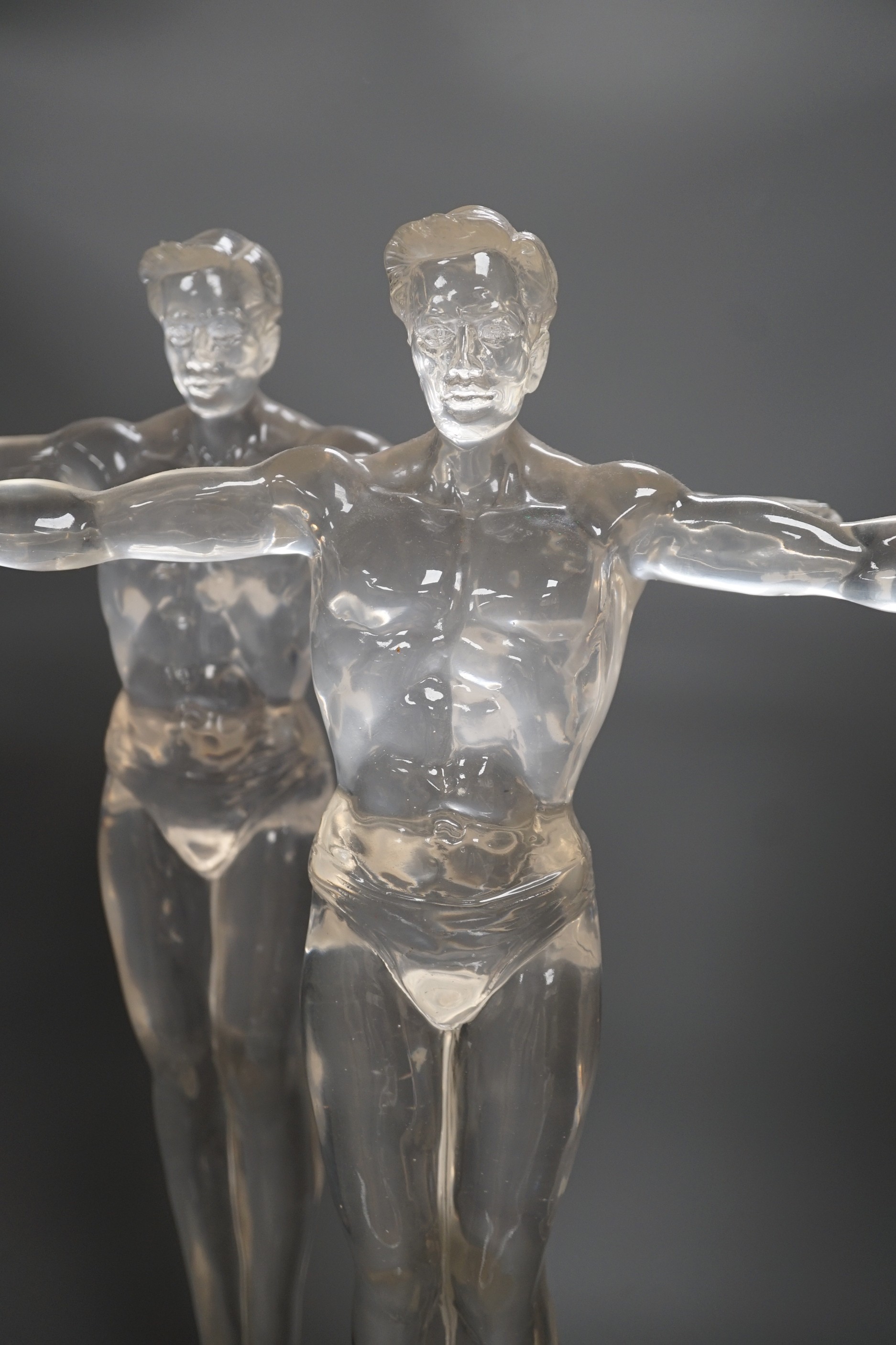 A pair of clear perspex models of male swimmers, 57cms high